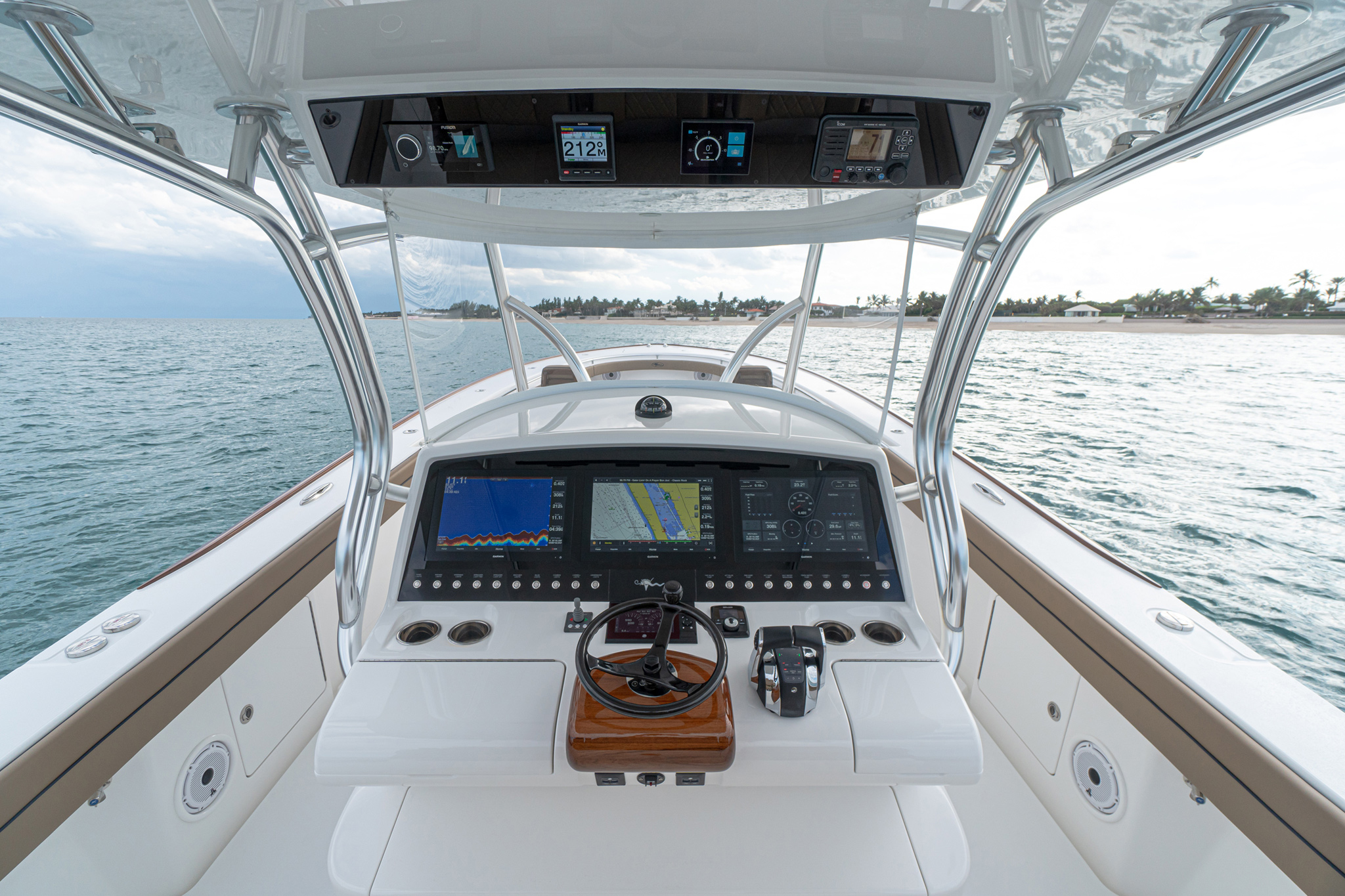 Clean helm layout, molded-in overhead electronics pod, Costa Clear single-panel enclosure (solid Pro Curve glass windshield also available).